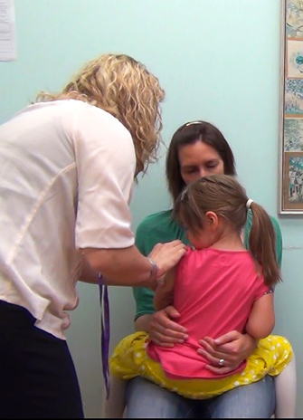 photo of a nurse administering a needle to a child