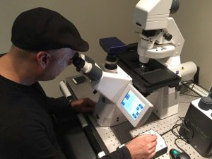 photo of Muhammad Yousaf looking into a microscope