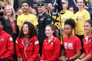 photo of President & Vice-Chancellor of York University, Rhonda Lenton, Schulich School of Business student and flag bearer, Sayam Khan, Brigadier-General Stephen Cadden, Commander, 4th Canadian Division, York U Professor Walter Perchal, Giovanna Cioffi, three-time graduate of York University, behind a row of York varsity athletes