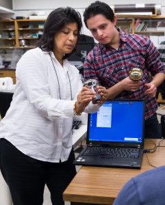 photo of Supervisor Sampa Bhadra, left, and Physics PhD student Elder Pinzon Guerra at work in the lab.