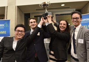 photo of four people raising a trophy over their head