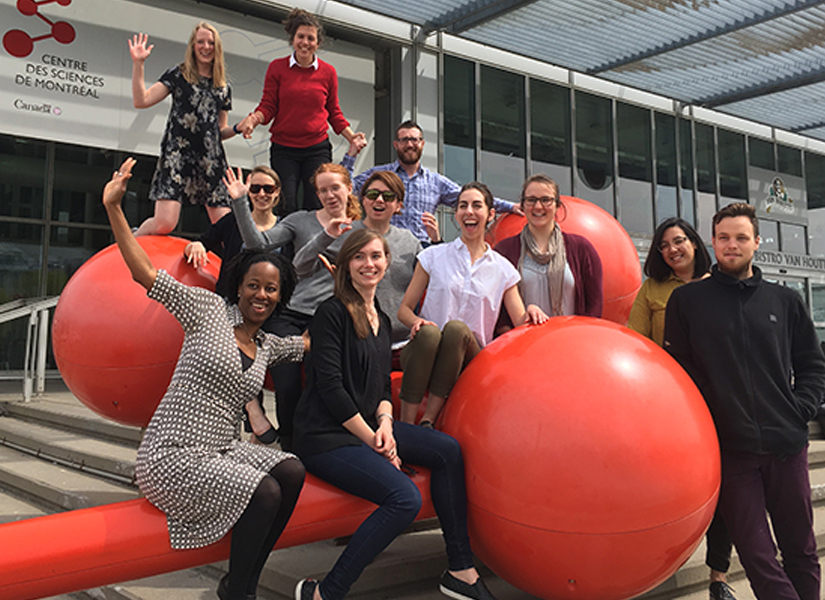 group of graduate students posing outside a science building